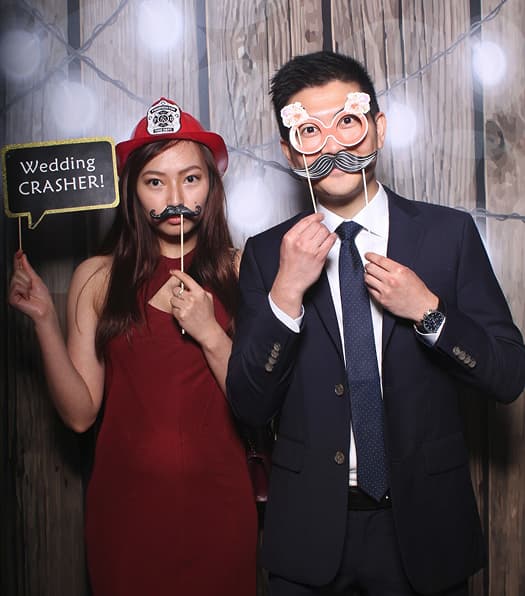 Wedding photo booth New Orleans couple posing with funny props and signs